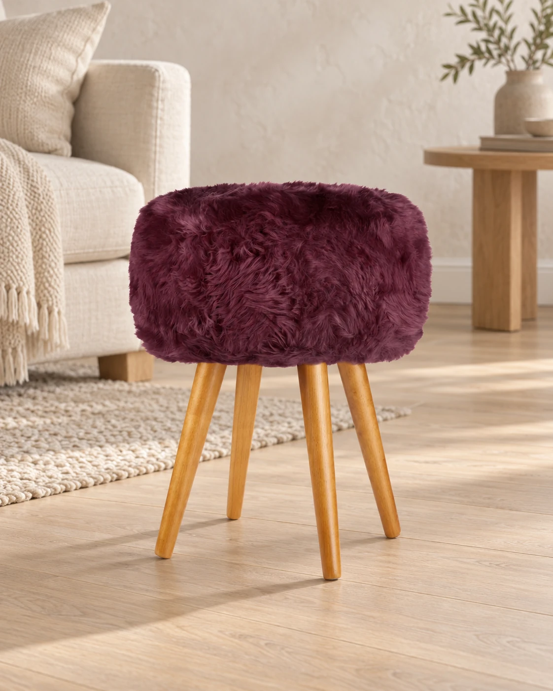Italian Plum sheepskin stool with oak legs in a light living room with cream upholstered furniture
